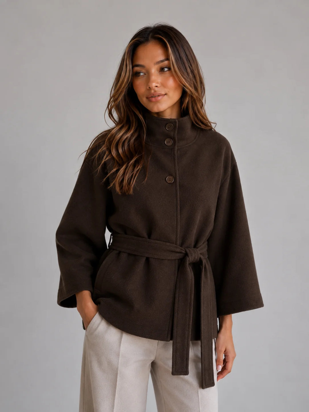Back view of cape jacket showing flowing sleeves and relaxed fit with adjustable belt