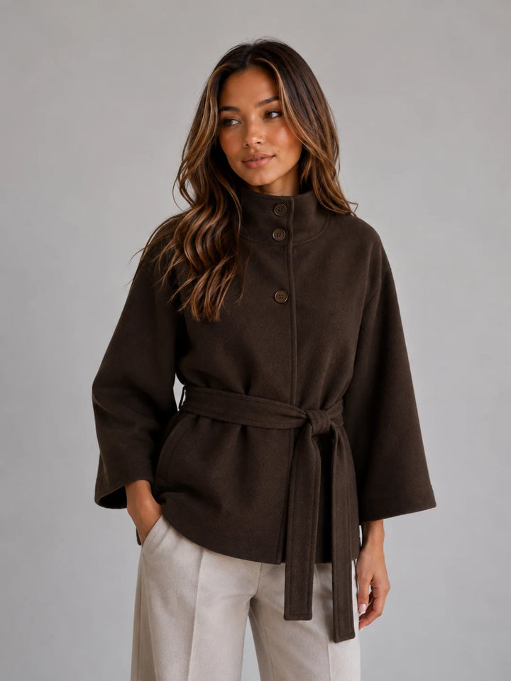 Back view of cape jacket showing flowing sleeves and relaxed fit with adjustable belt