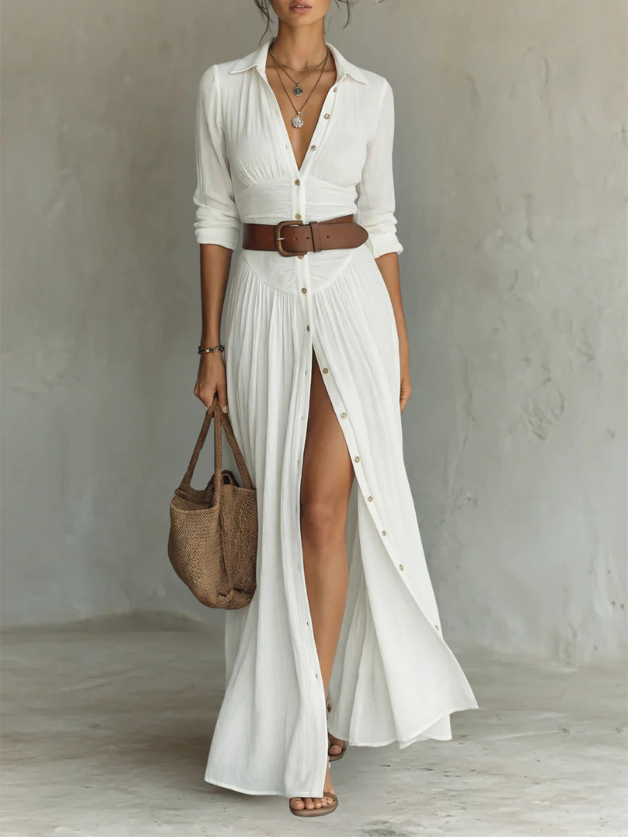 Pleated maxi shirt dress in white with classic collar and button-front closure worn with brown belt