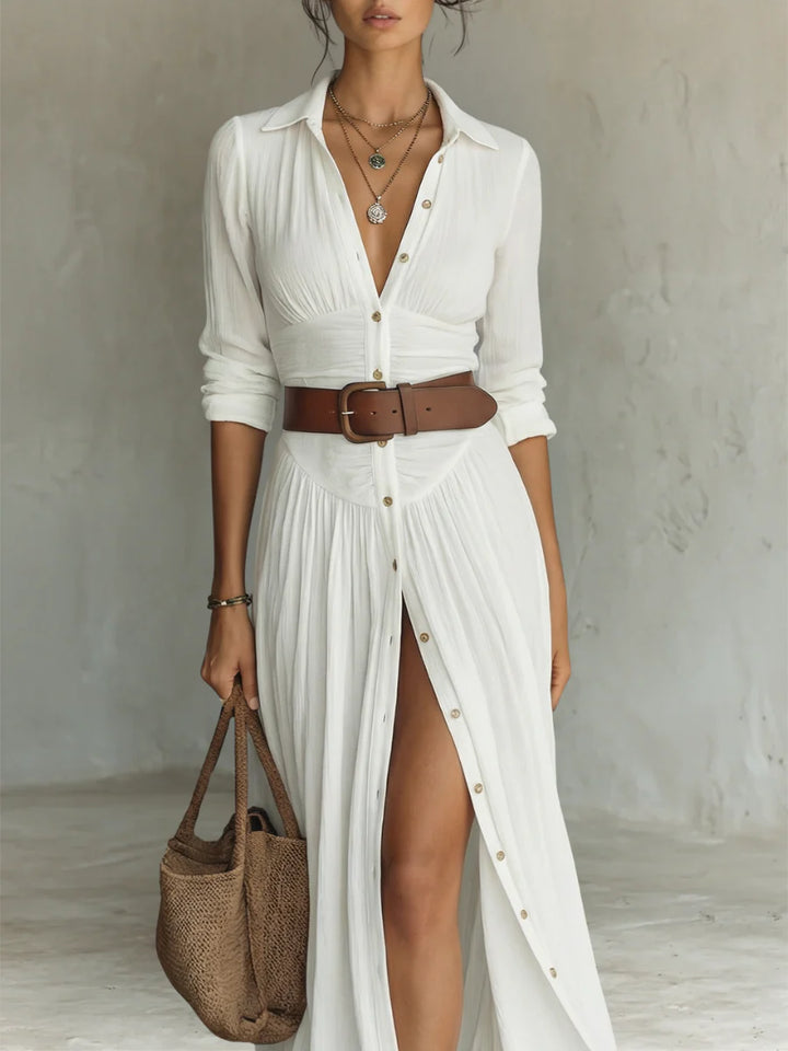Side view of white pleated maxi shirt dress with front slit and long sleeves