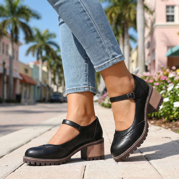 Rear view of women's black T-strap block heel shoes highlighting chunky tread sole and heel construction