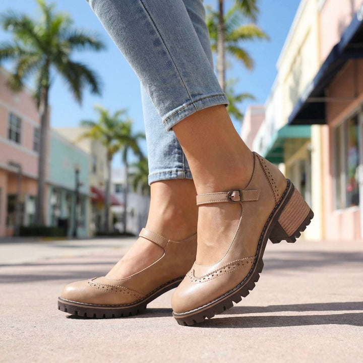 Detail shot of women's T-strap block heel shoes showing contrast stitching and buckle fastening mechanism