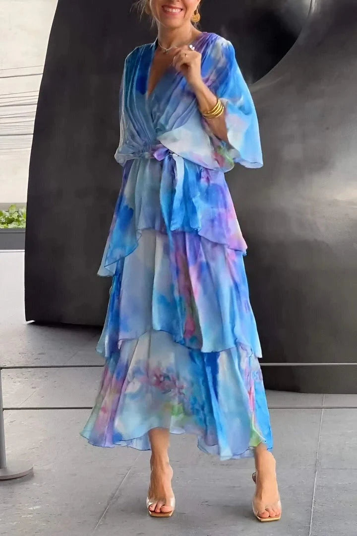 Styling shot of tie-dye tiered maxi dress paired with strappy sandals and metallic clutch