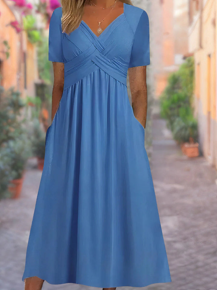 Close-up of crossover bodice detailing on V-neck midi dress with empire waistline