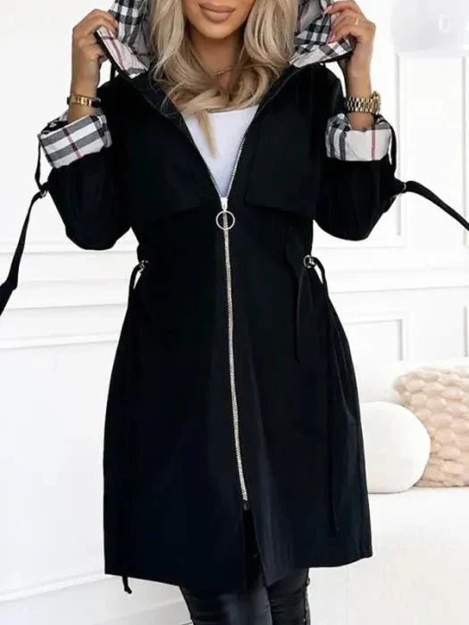 Side view of midi-length hooded trench coat with adjustable cuffs and tailored fit