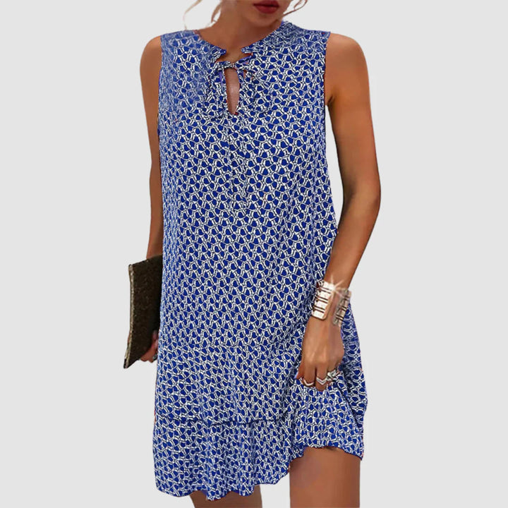 Printed shift dress with geometric pattern and keyhole neckline worn by model in studio setting