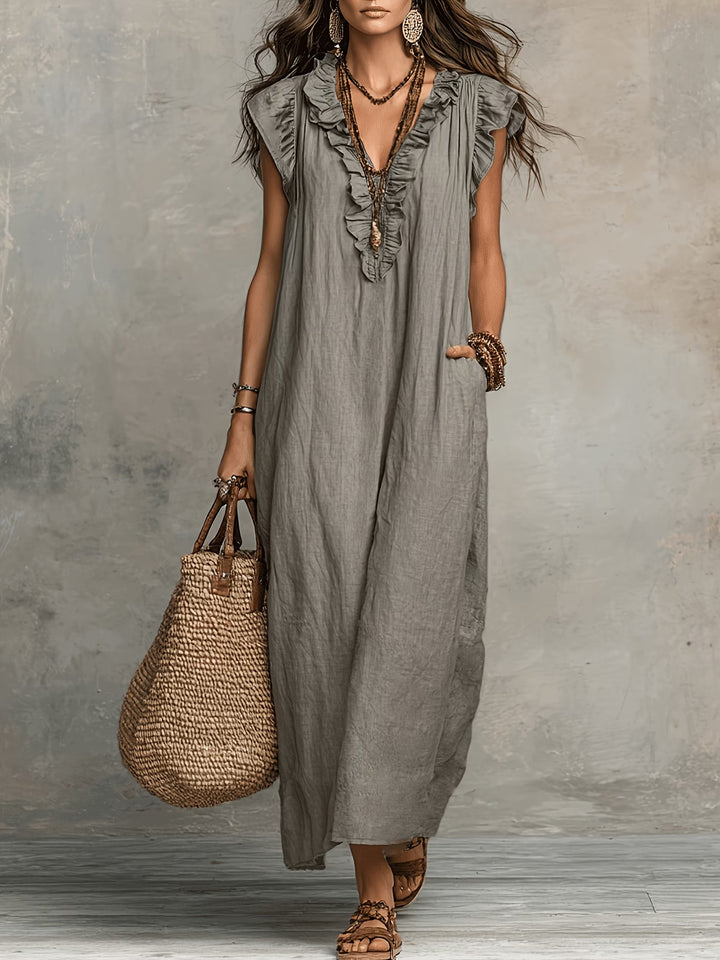 Close-up view of ruffle detailing and V-neckline on sleeveless maxi dress in blue