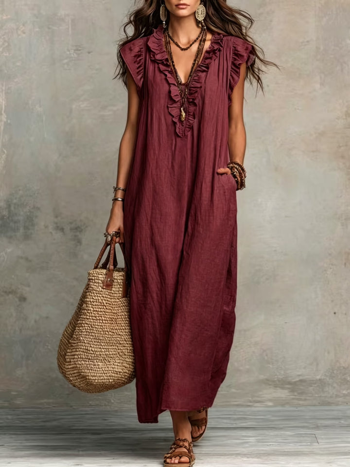 Full-length view of blue ruffle sleeveless dress styled with sandals and woven bag