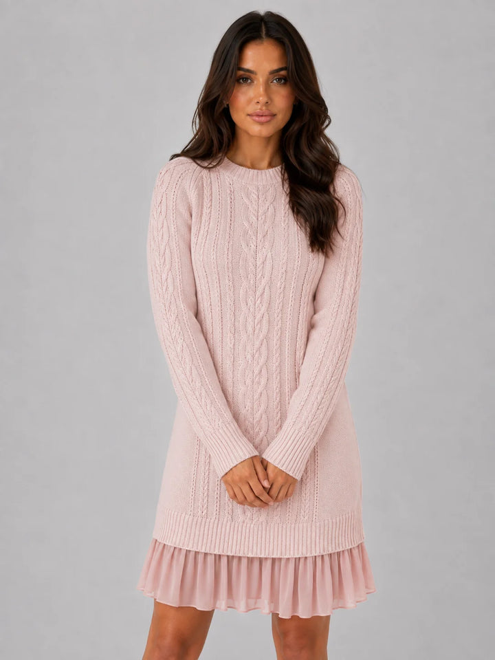 Side view of relaxed fit cable knit dress with ribbed cuffs and pleated skirt contrast
