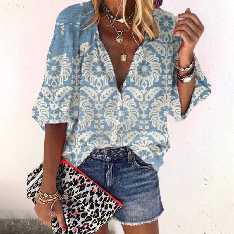 Women's V-neck blouse in sage green floral print paired with jeans and layered necklaces