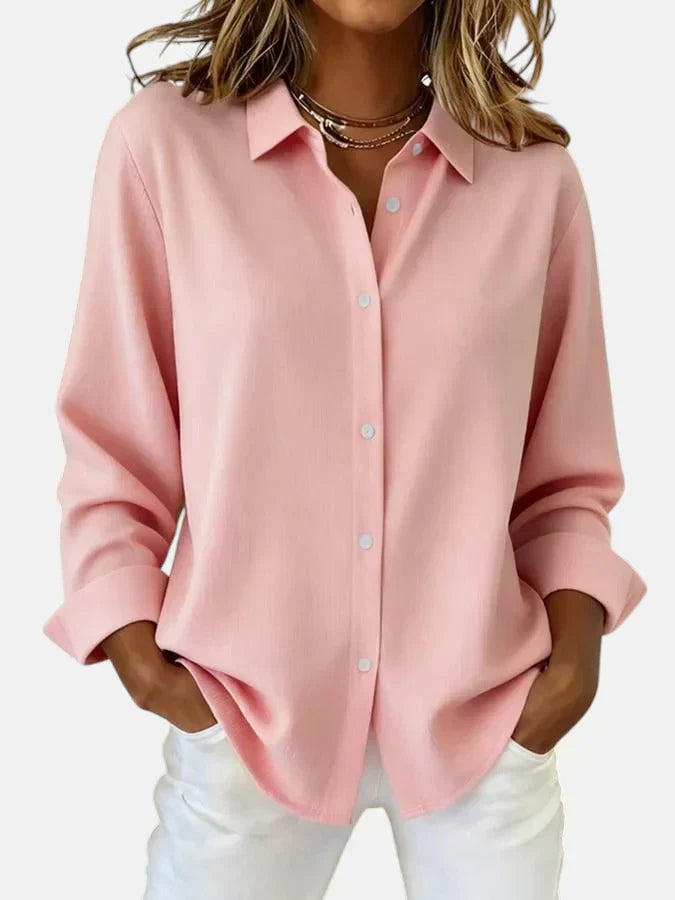 Close-up view of women's oversized pink shirt showing relaxed boxy fit and contrast button detail