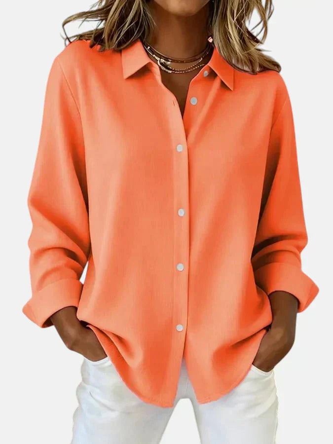Women's oversized pink shirt styled casually with sleeves rolled and tucked into white denim trousers