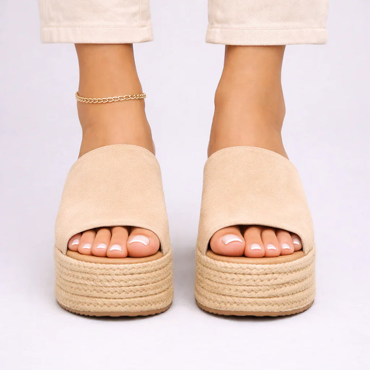 Close-up view of women's espadrille wedge sandals showing jute-wrapped platform and wide upper band