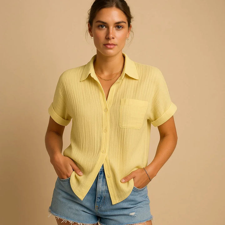 Women's relaxed shirt styled with denim shorts showing oversized fit and button closure