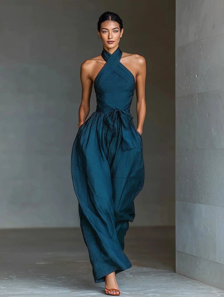 Close-up view of halter neck wide-leg jumpsuit showing cross-front neckline and adjustable tie waist detail