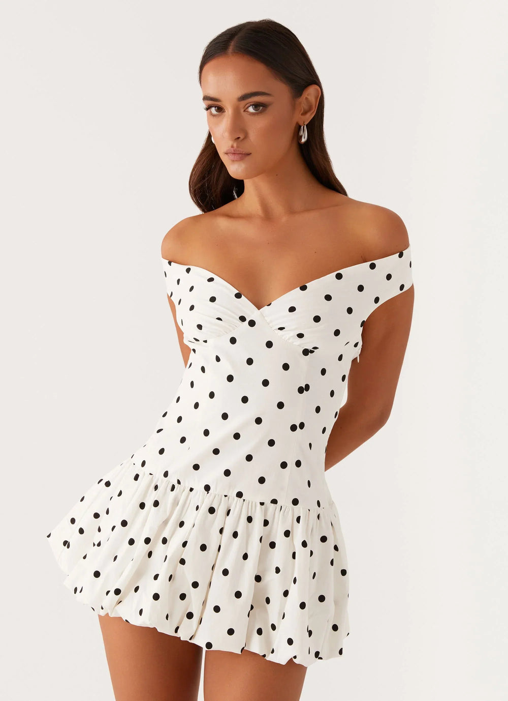 Close-up view of the Off-Shoulder Polka Dot Peplum Mini Dress showing the structured off-shoulder neckline and playful polka dot pattern across the bodice