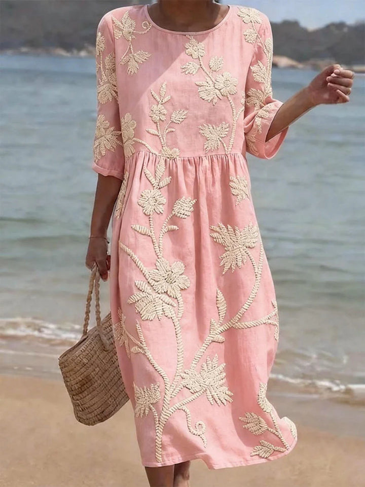 Side view of embroidered floral midi dress with relaxed fit and gathered waist styling