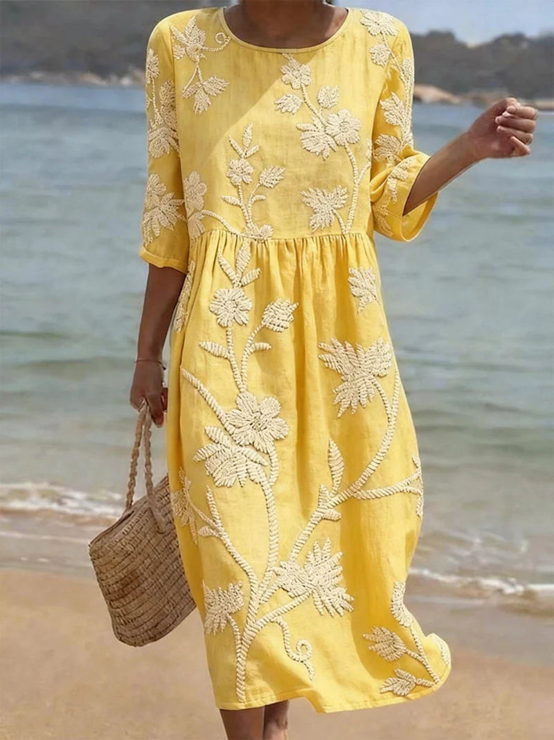 Detail shot of embroidered floral midi dress showing round neckline and sleeve construction