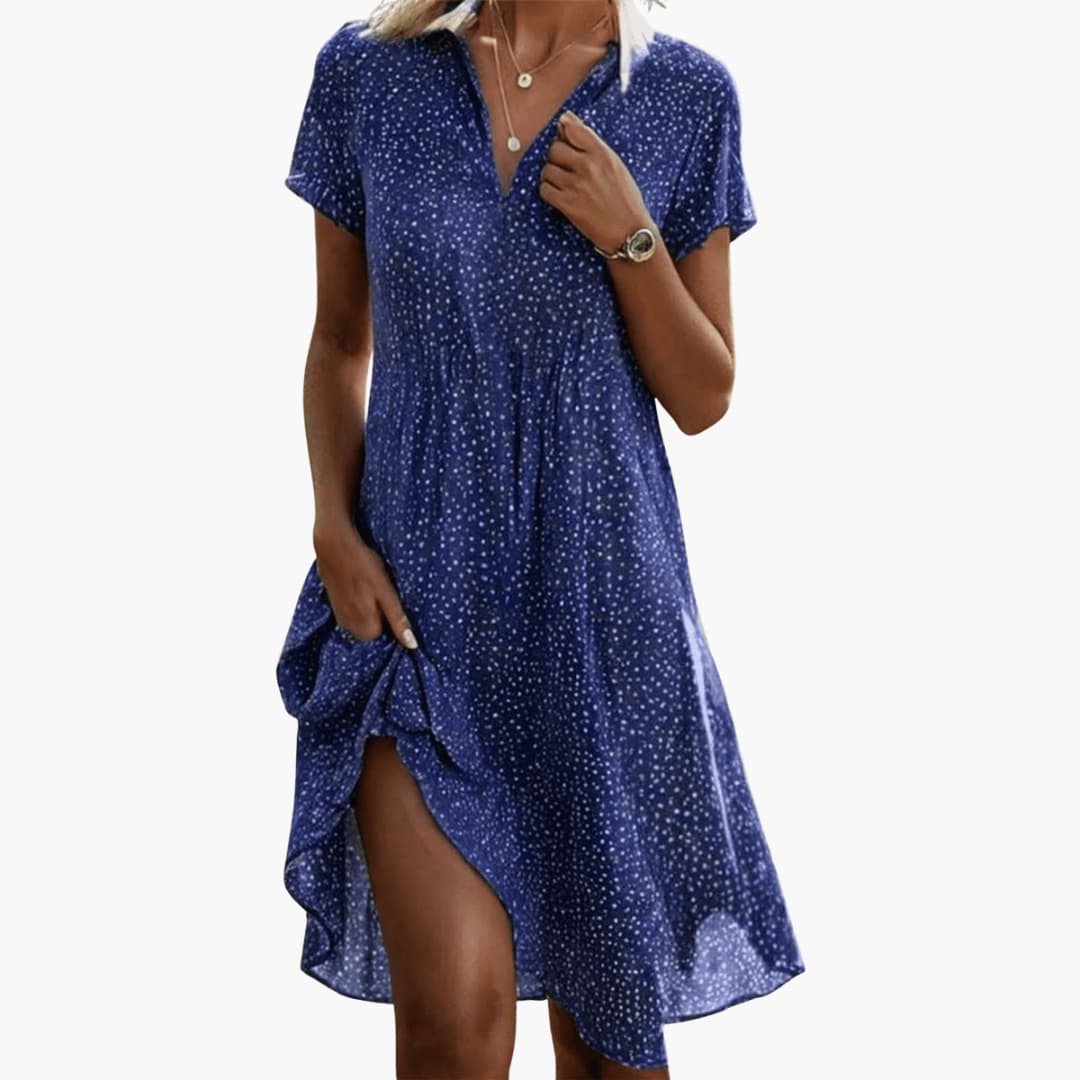 Woman wearing navy polka dot midi dress with V-neckline and short sleeves in relaxed fit