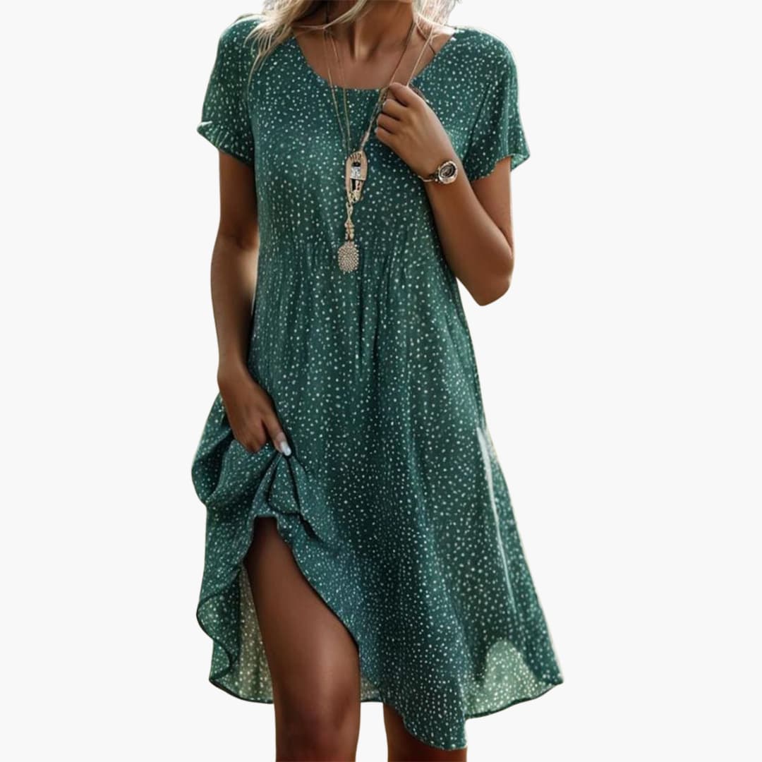 Side view of navy polka dot midi dress displaying A-line silhouette and front slit hem