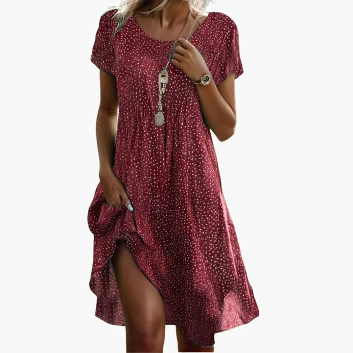 Full-length view of polka dot midi dress with short sleeves and side pocket detail