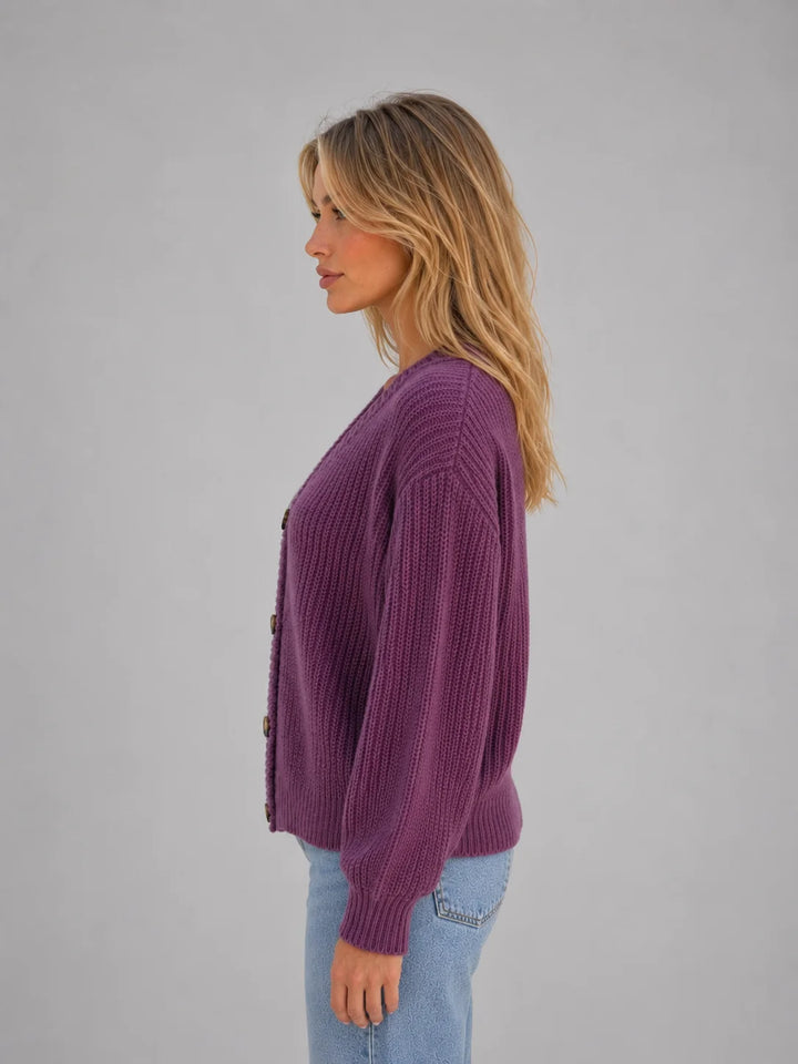 Side angle of relaxed fit chunky knit cardigan showing ribbed cuffs and hem detail