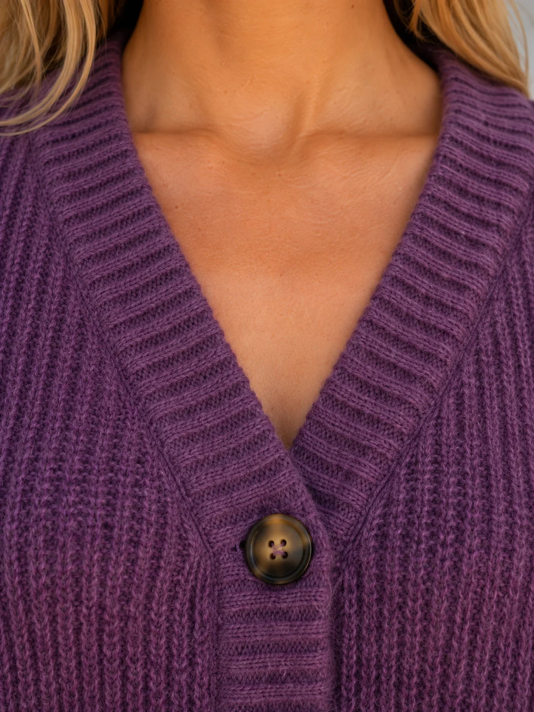 Women's V-neck cardigan in chunky ribbed knit fabric styled with casual denim jeans
