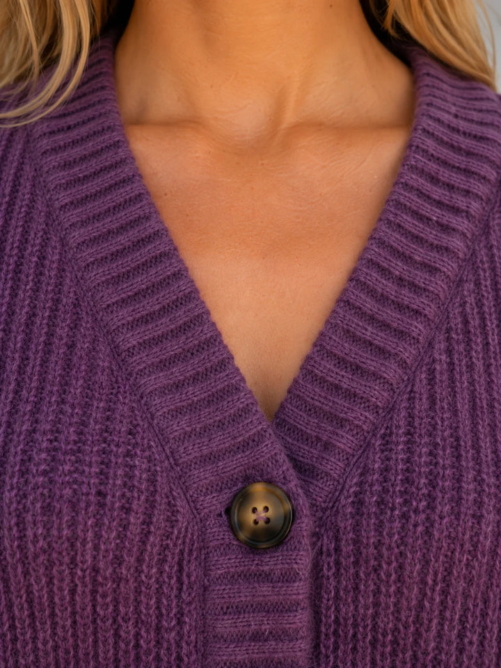 Women's V-neck cardigan in chunky ribbed knit fabric styled with casual denim jeans