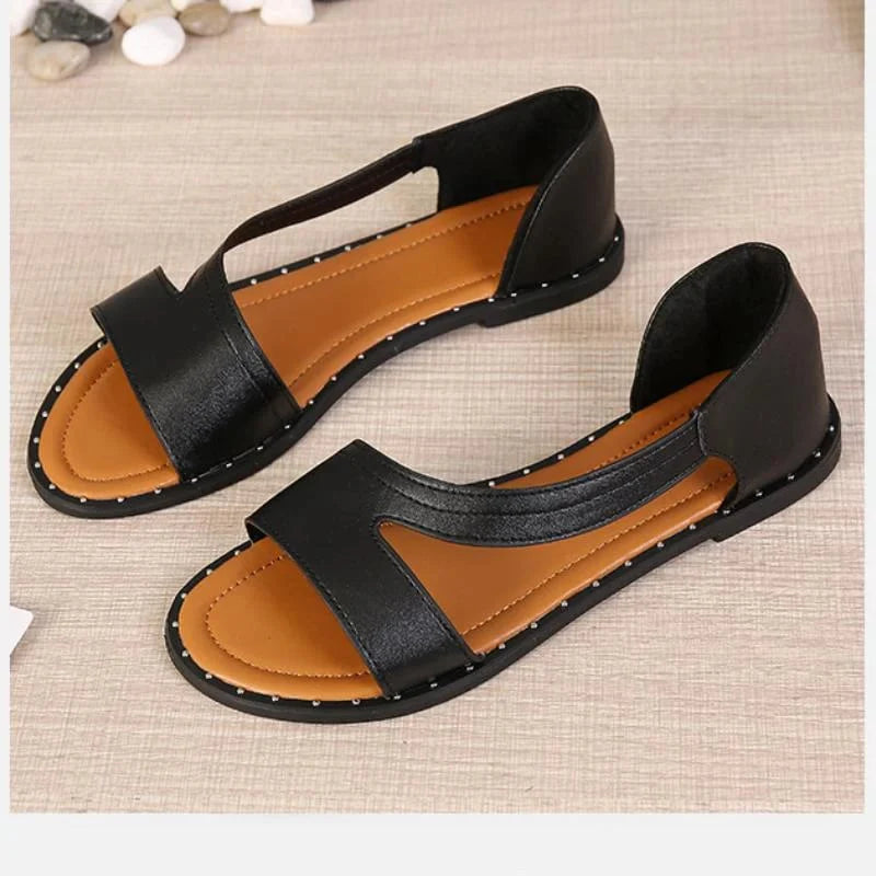 Close-up view of women's flat sandals showing adjustable slingback strap and cushioned insole