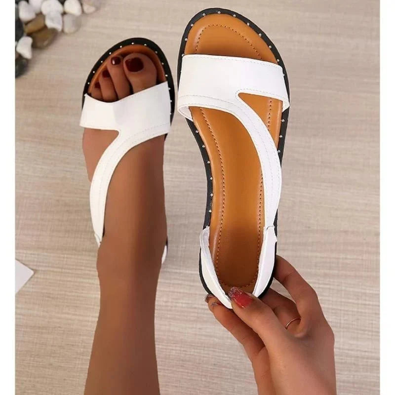 Detail of crossover strap sandals with visible stitching and contoured footbed