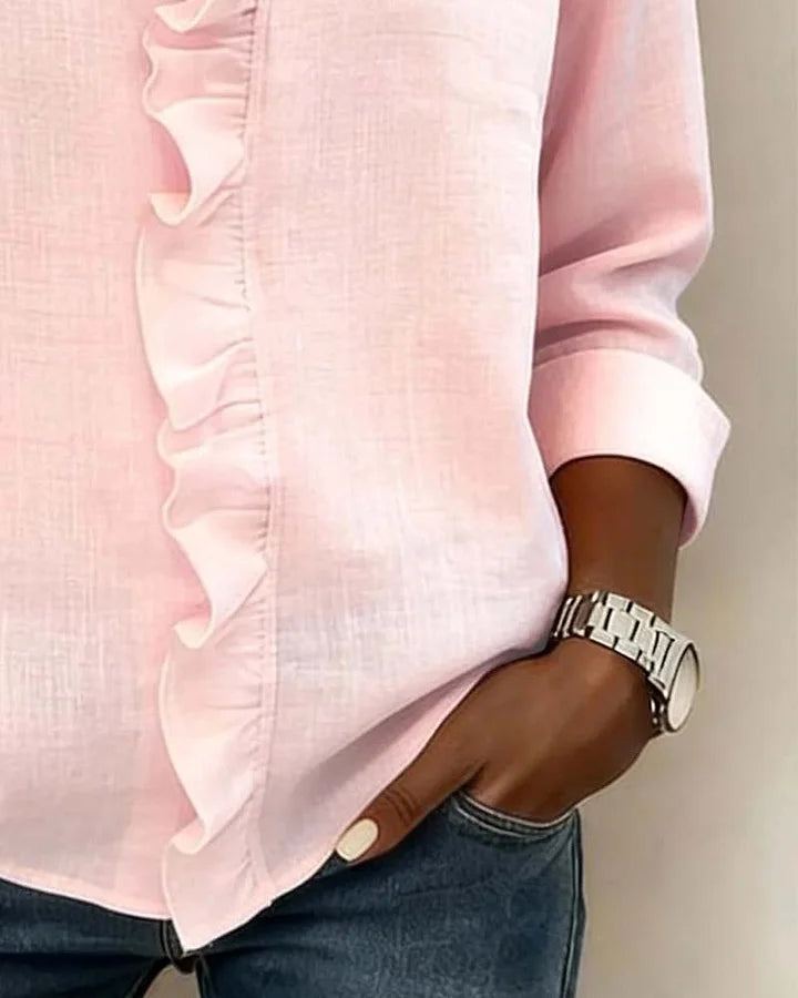 Women's ruffle neck blouse worn casually with jeans and a watch accessory