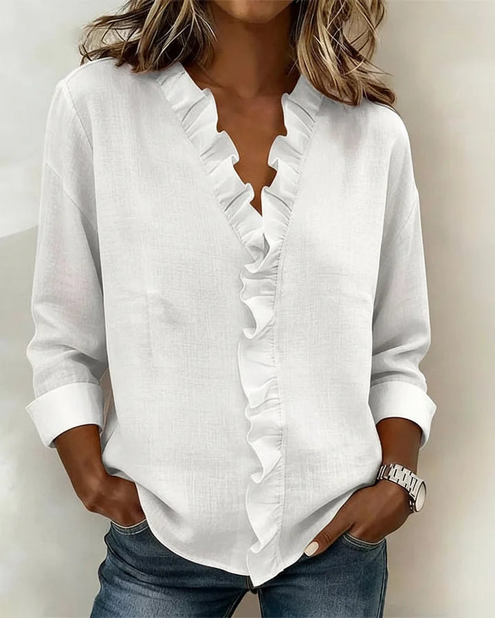 Close-up of ruffle trim detail along V-neckline on women's blouse