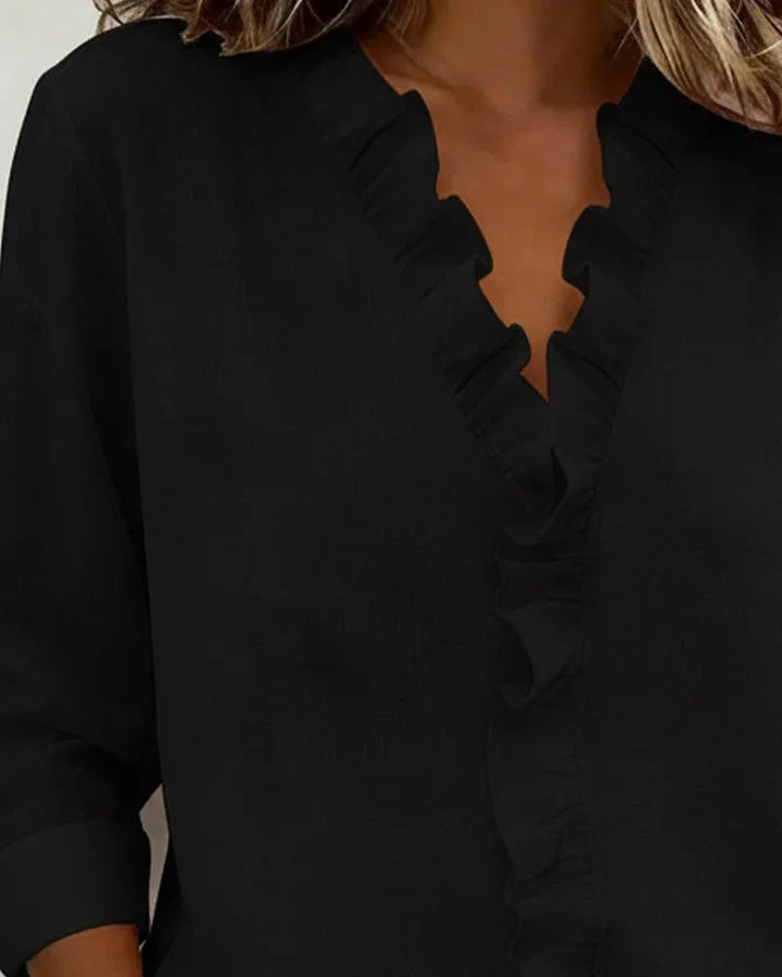 Women's ruffle neck blouse in green paired with casual trousers