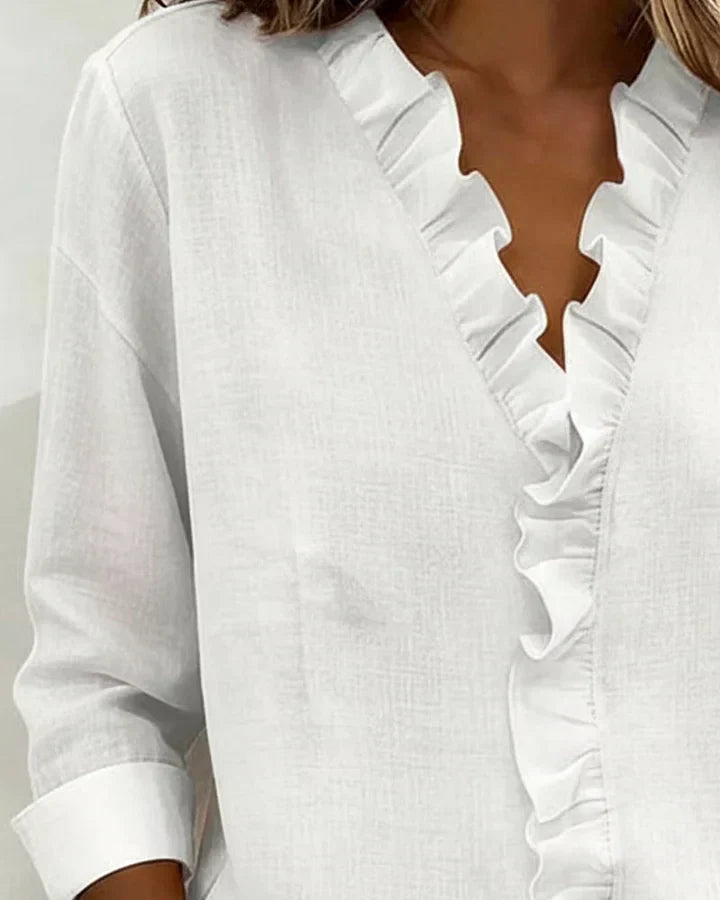 Women's ruffle neck blouse in blue styled for office wear with tailored trousers