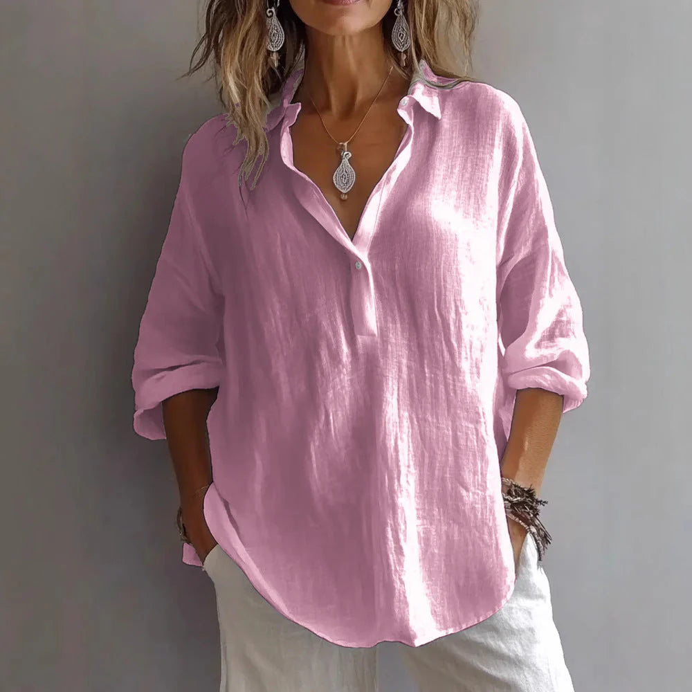 Side angle of women's white linen shirt displaying loose fit, curved hem, and collarless V-neckline design