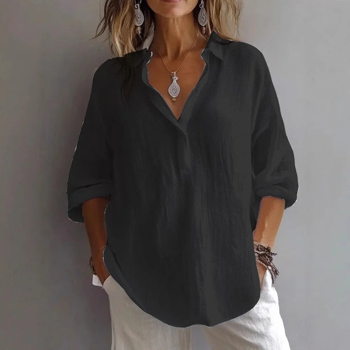 Woman styling white linen shirt casually, highlighting three-quarter sleeves and effortless summer aesthetic