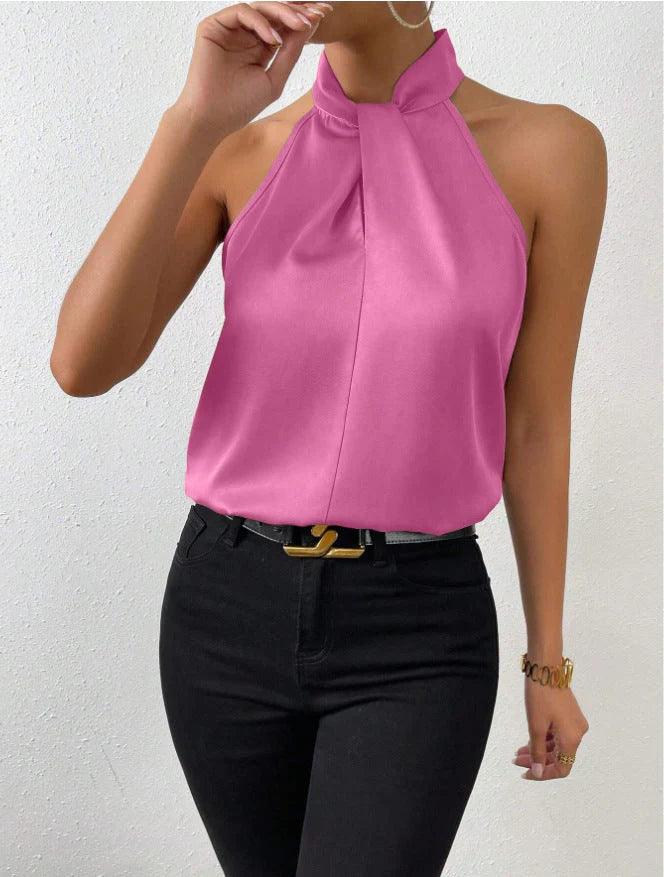 Detail view of twisted neckline construction on women's satin halter blouse
