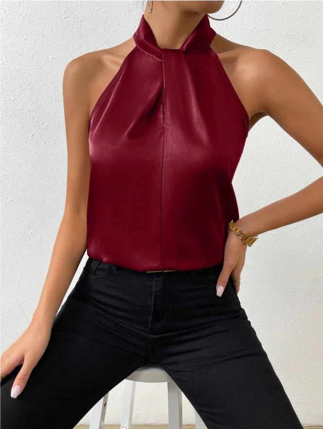 Women's champagne satin blouse styled with black tailored trousers and leather belt for office wear