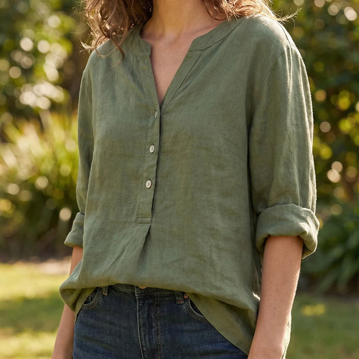 Side view of relaxed-fit women's linen shirt with curved hem and fluid drape