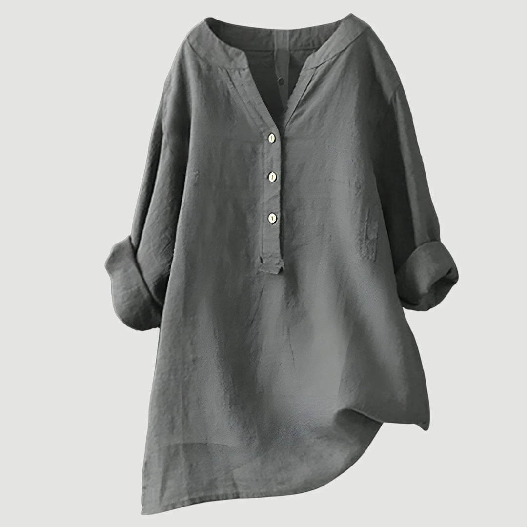 Women's coral linen shirt on neutral background highlighting fluid drape and curved hem