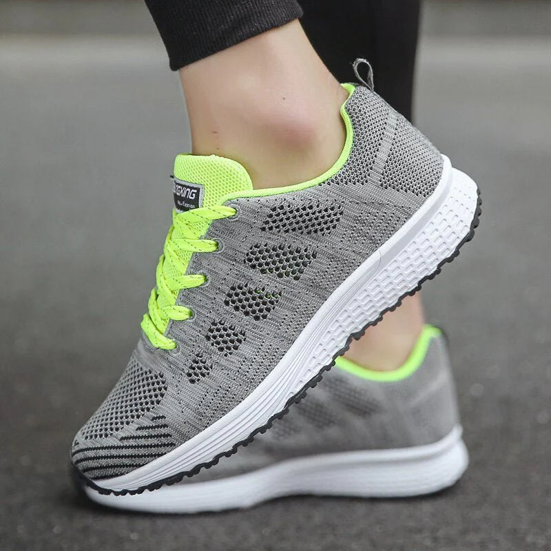 Side profile of women's white trainers showing supportive structure and breathable knit