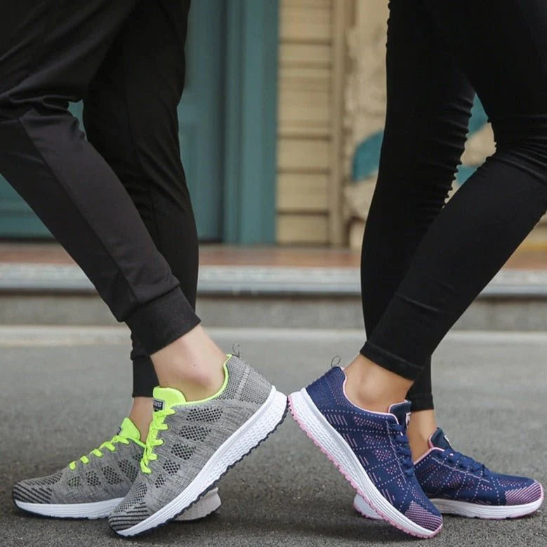 Women's white lace-up trainers styled for everyday wear with casual trousers