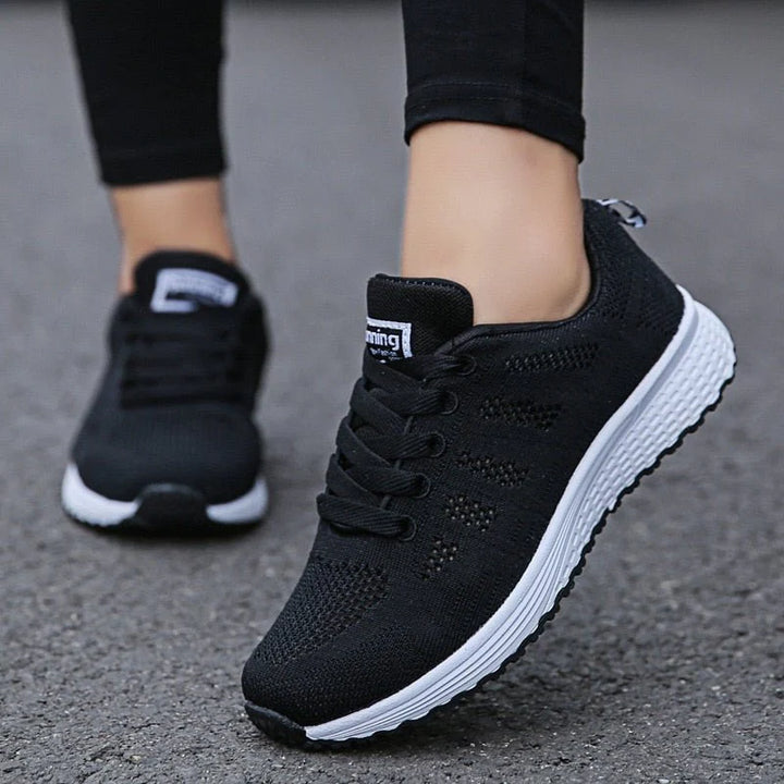 Women's white trainers with textured outsole for grip on varied surfaces