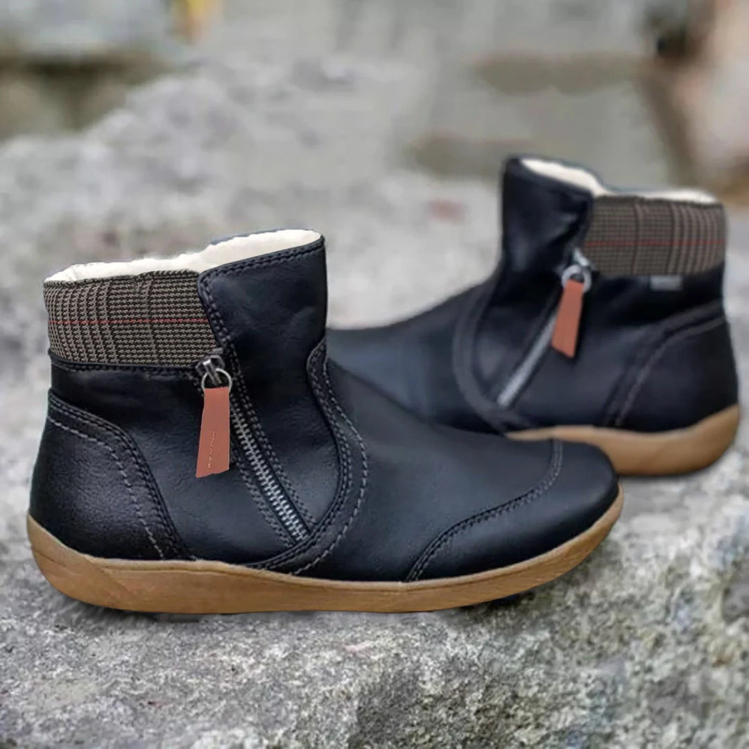 Close-up view of ankle-height waterproof boots showing structured material and decorative zip detail