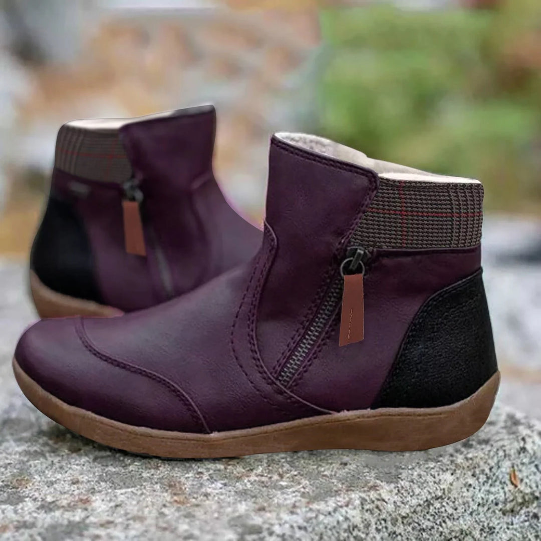 Detail shot of side zip closure with contrasting orange pull tab on green ankle boots