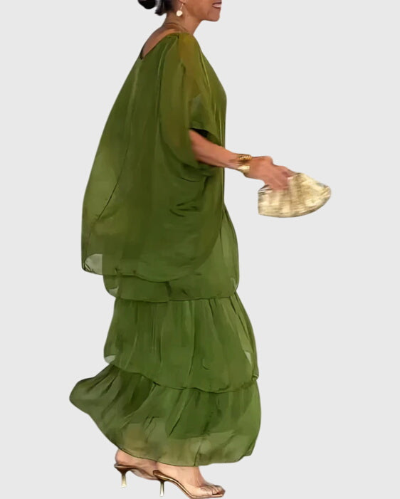 Close-up of relaxed-fit green top with dolman sleeves on layered maxi dress