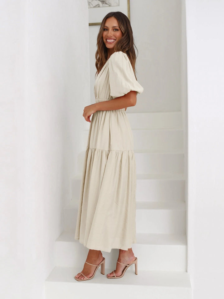 Full-body view of midi dress with puff sleeves and flowing skirt