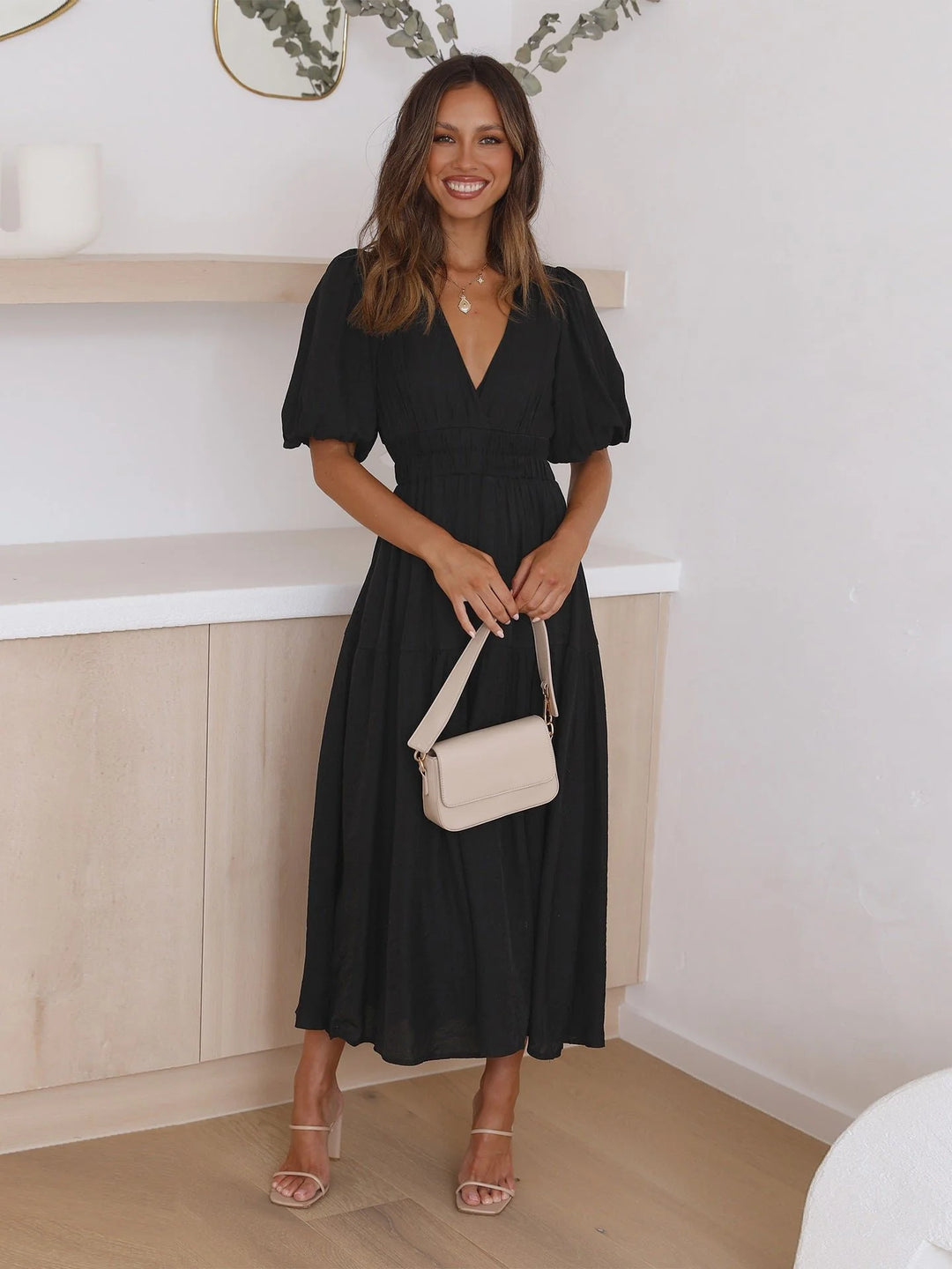 Detail of deep V-neckline and elasticated smocked waist on midi dress