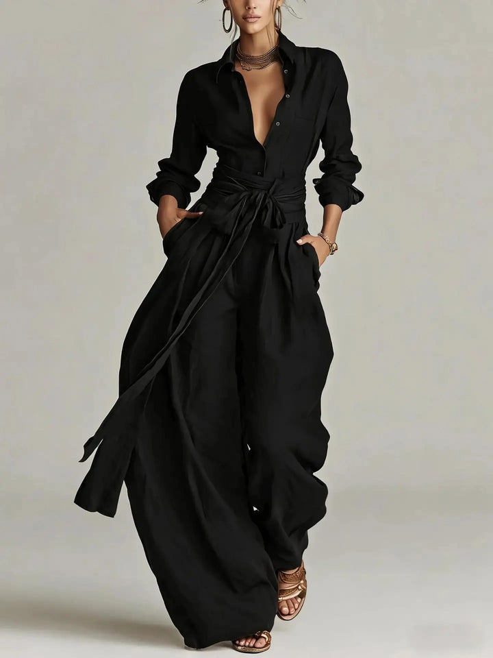 Close-up view of belted long-sleeve jumpsuit showing button-front bodice and waist belt detail