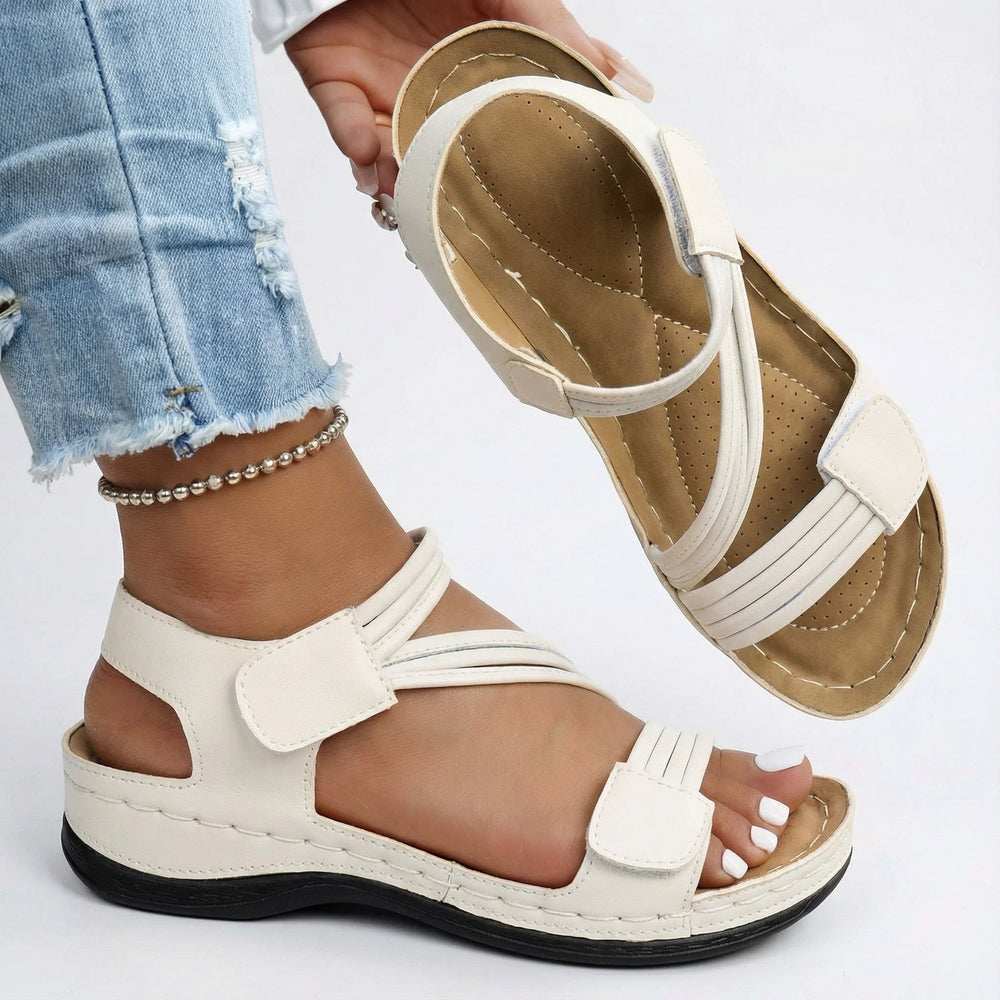 Close-up view of pink orthopedic sandals showing hook-and-loop ankle strap and contoured insole design